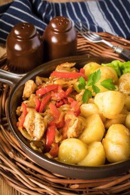 Kırmızı biberli ve soğanlı kızarmış tavuk parçaları, patates ile servis edilir..