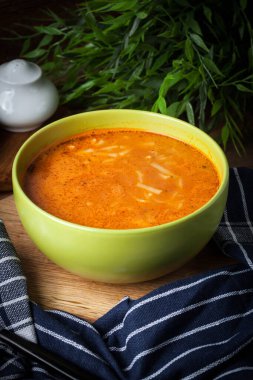 Domates çorbası erişte ahşap bir masa üzerinde. Karanlık ışık.