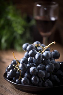 Kara üzüm kase ahşap masa üzerinde. Seçici odak.