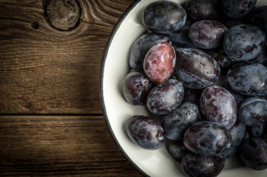 Bahçe Erik kase ahşap masa üzerinde. Metniniz için kopya alanı ile Üstten Görünüm.