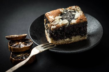 Karanlık bir arka plan üzerinde haşhaş tohum kek. Karanlık ışık.