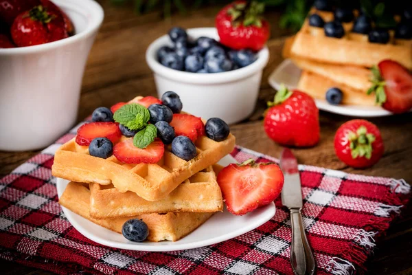 Bir tabak meyve ile waffle yığını. Küçük alan derinliği.