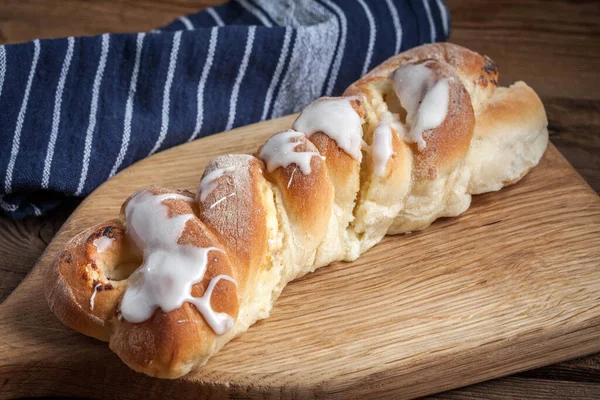 Kesme tahtasına örülmüş tatlı çörek. Seçici odak.