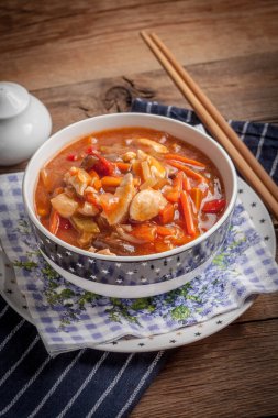 Ahşap masa üzerinde sebzeli Çin usulü tavuk. Seçici odak.