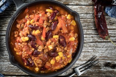 Ahşap arka planda kızartma tavasında Chili con carne. Seçici odak.