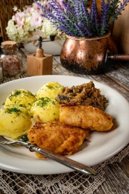 Kızarmış morina filetosu, haşlanmış patates ve mantarlı kızarmış lahana turşusu..