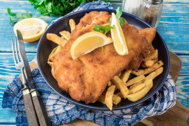 Tabağında patates kızartması olan kızarmış morina balığı..