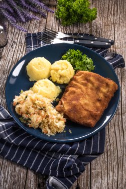 Akşam yemeğinde patates ve lahana turşusu salatası ile haşlanmış balık. Seçici odak.