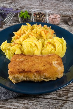 Haşlanmış patates ve sebze salatasıyla servis edilen kızarmış morina filetosu..