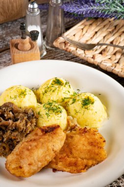 Kızarmış morina filetosu, haşlanmış patates ve mantarlı kızarmış lahana turşusu..