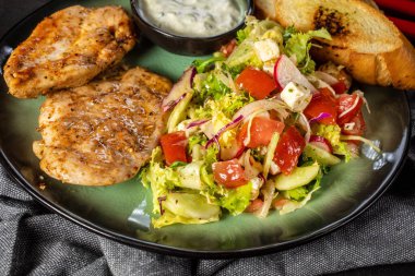 Izgara tavuk eti ve taze sebze salatası, marul, roka, turp, salatalık ve domates. Koyu ışık..