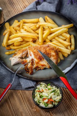 Pastırma ve peynirle doldurulmuş kızarmış tavuk göğsü patates kızartması ve salata ile servis edilir. Küçük alan derinliği.