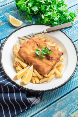 Tabağında patates kızartması olan kızarmış morina balığı..