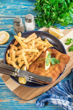 Tabağında patates kızartması olan kızarmış morina balığı..