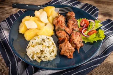 Şiş kebap - ızgara et, kızarmış patates ve sebze.