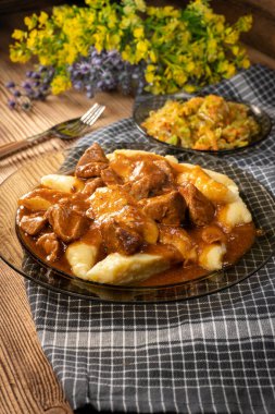 Soslu sığır eti yahnisi, patates köftesiyle servis edilir..