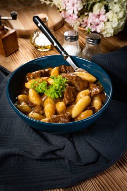 Soslu sığır eti yahnisi, patates köftesiyle servis edilir..