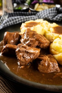 Sos ve patates püresiyle servis edilen haşlanmış hindi eti. Sığ alan derinliği. 