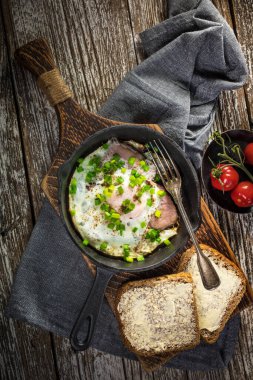 Eski ahşap arka planda jambonlu sahanda yumurta. Üst görünüm.