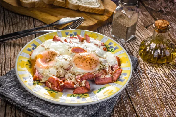 Eski ahşap arka planda sosisli sahanda yumurta..