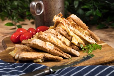 Kızarmış peynirli sandviçi doğrama tahtasında. Sığ alan derinliği.