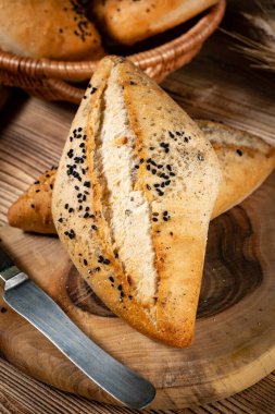 Köy ahşap bir masada taze ekmek ruloları. Kahvaltı için fırından taze ekmek ruloları..