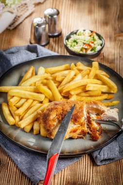 Pastırma ve peynirle doldurulmuş kızarmış tavuk göğsü patates kızartması ve salata ile servis edilir. Küçük alan derinliği.