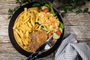 Geleneksel Polonya yemeği: kızarmış domuz pirzolası, patates kızartması ve salata ile servis edilir.. 