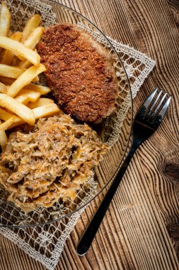 Patates kızartması ve haşlanmış lahana ile servis edilen domuz pirzolası. Seçici odak.