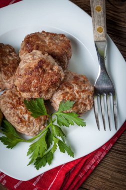 Kızarmış domuz eti köfte beyaz bir plaka üzerinde.