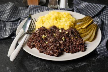 Kızarmış puding, patates püresi ve salatalık turşusu..