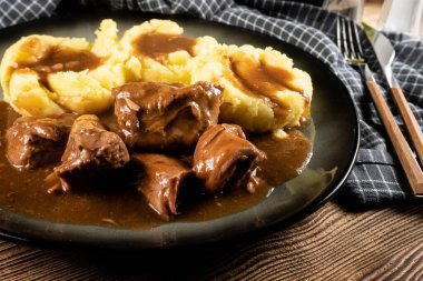 Sos ve patates püresiyle servis edilen haşlanmış hindi eti. Sığ alan derinliği. 