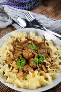 Tagliatelle yosunuyla servis edilen kendi soslu mantarlı domuz köftesi..