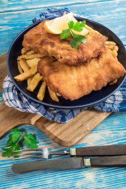 Tabağında patates kızartması olan kızarmış morina balığı..