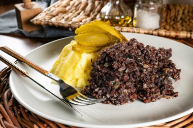 Kızarmış puding, patates püresi ve salatalık turşusu..