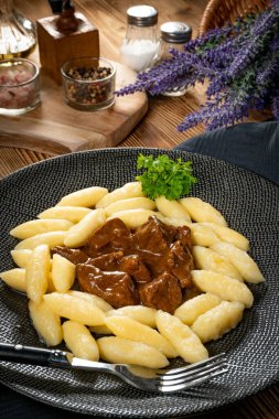 Soslu sığır eti yahnisi, patates köftesiyle servis edilir..