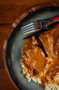 Kendi soslu haşlanmış domuz boyunlu arpa ve salatayla servis ediliyor. Sığ alan derinliği.