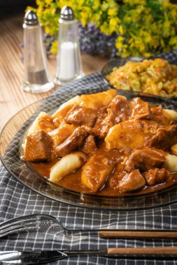 Soslu sığır eti yahnisi, patates köftesiyle servis edilir..