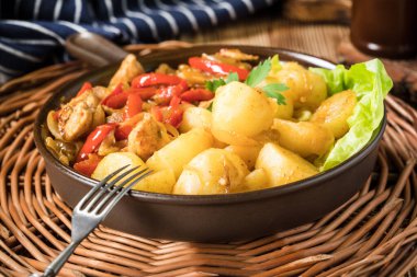 Kırmızı biberli ve soğanlı kızarmış tavuk parçaları, patates ile servis edilir..