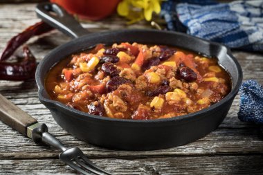 Ahşap arka planda kızartma tavasında Chili con carne. Seçici odak.