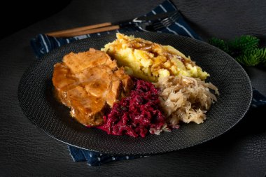 Patates püresi ve salata ile servis edilen soslu domuz budu..