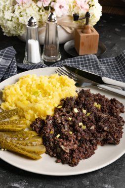 Kızarmış puding, patates püresi ve salatalık turşusu..