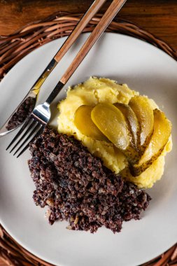 Kızarmış puding, patates püresi ve salatalık turşusu..