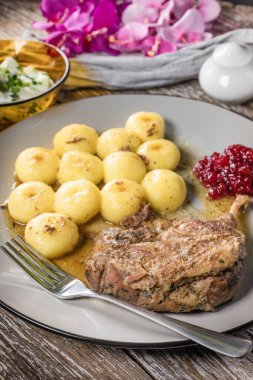 Kızarmış ördek bacağı, patates köftesi ve kızılcık..