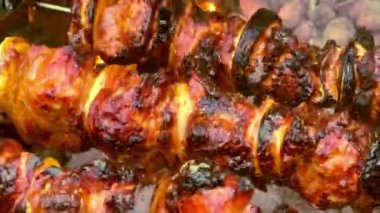 Domuz eti ve sebzeler ızgarada metal şişler üzerinde kızartılır..