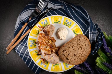 Kızarmış beyaz sosis, soğanlı ve rendelenmiş yaban turpu. Küçük alan derinliği.