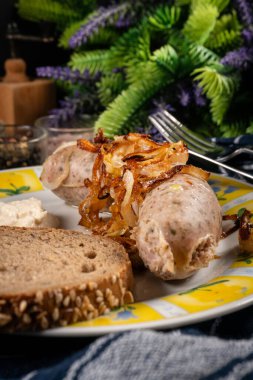 Kızarmış beyaz sosis, soğanlı ve rendelenmiş yaban turpu. Küçük alan derinliği.