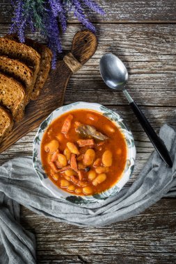 Domates soslu fasulye, pastırma ve sosis. Seçici odak.