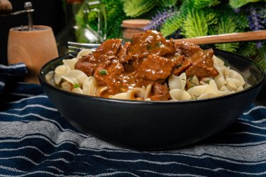 Siyah kasede sığır etli makarna. Sığ alan derinliği.