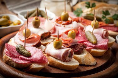 İspanya mutfağı. Tapas dilimlenmiş sosis, salam, zeytin ve ahşap bir masa üzerine maydanoz ile.